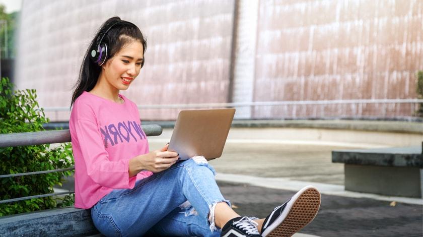 Asian female high school student prepares college application on laptop  - Connections Academy